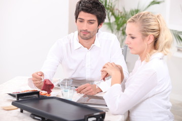 Obraz na płótnie Canvas Couple cooking meat on hotplate