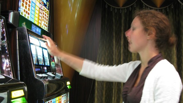 woman sitting at slot machine in casino, time lapse
