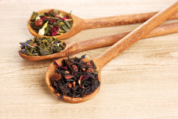 Different kinds of green and black dry tea in spoons