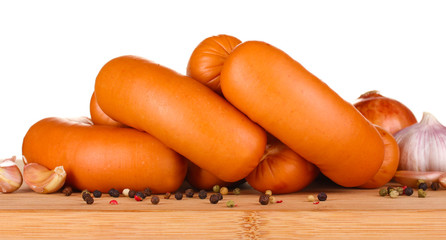 tasty sausages on wooden board and spices isolation on white