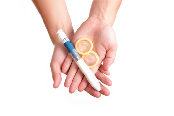 syringe needle (for ovulate) and condom holding by hands