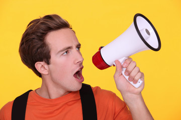 Young man hollering into a megaphone