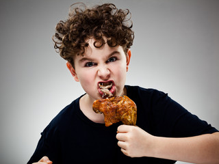 Boy eating roasted chicken leg