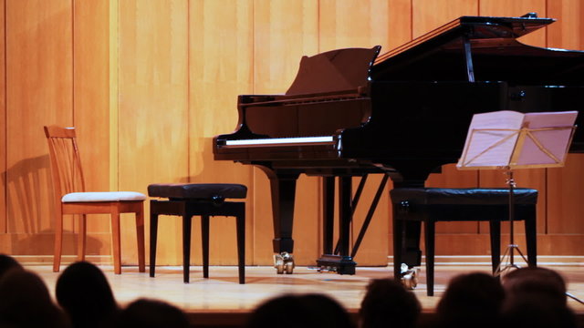 grand piano on stage, people wait of musician