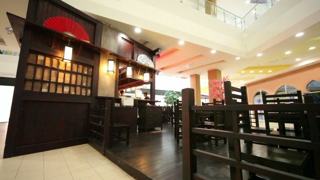 Bartender and waiter in few empty restaurant in eastern style