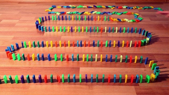 Dominoes row begin to fall down one by one