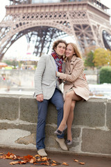 Fototapeta premium Beautiful romantic couple in Paris near the Eiffel Tower