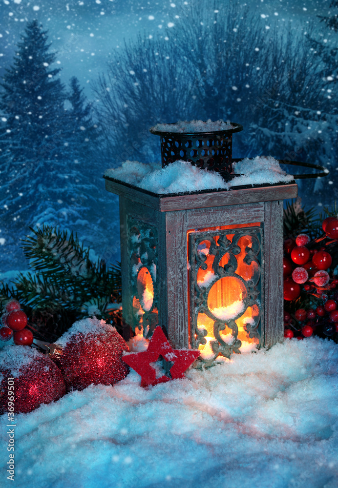 Wall mural burning lantern in the snow at night