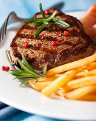 Grilled steak with french fries and rosemary