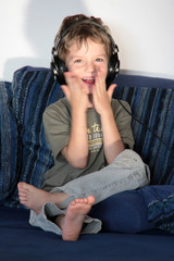 Ein Kind mit Kopfhörer freut sich beim Musik hören