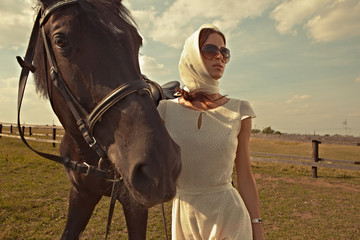 beautiful girl in a white gown with horse on nature