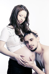 Beautiful future parents: his pregnant wife and a happy husband