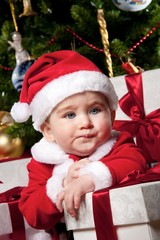 Tired little boy with a gift boxes.