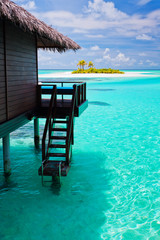 Over water bungalow with steps into blue lagoon - obrazy, fototapety, plakaty