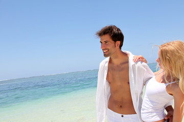 Fototapeta premium Couple walking on white sandy beach