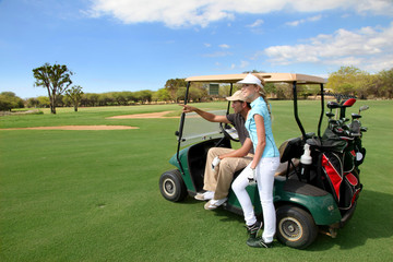 Couple on golf course with cart