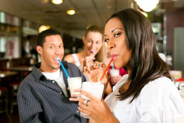 Freunde trinken Milchshakes in einer Bar