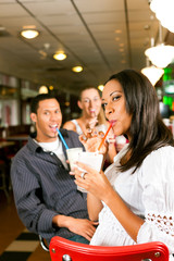 Freunde trinken Milchshakes in einer Bar