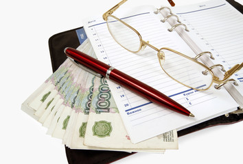 Business still-life. Money and the daily log