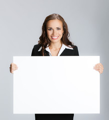 Businesswoman showing signboard, over grey