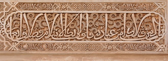 Arabic stone engravings on the Alhambra palace wall - obrazy, fototapety, plakaty