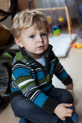 adorable baby boy with blond hairs and blue eyes