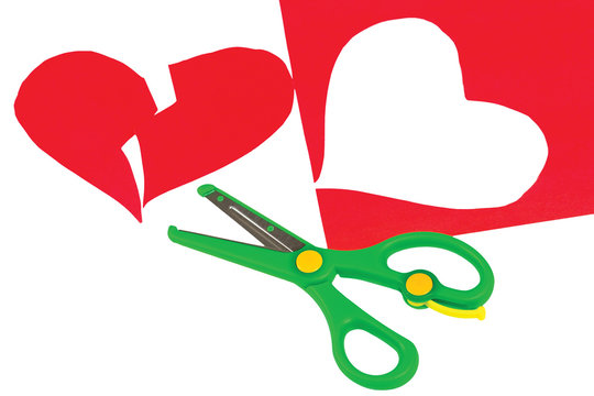 Broken red heart and scissors on a white background
