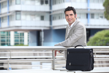 Businessman with a briefcase standing in an urban environment