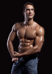 young muscular man isolated on black background - obrazy, fototapety, plakaty