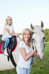 Mother and daughter with a horse