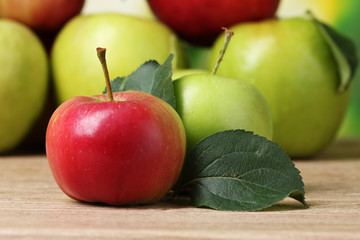 Many fresh organic apples on wooden table