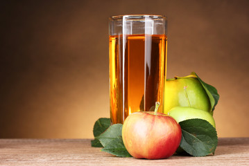 Glass of healthy fresh juice of apples on brown background