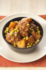 Homemade meatballs with green peas and potatoes