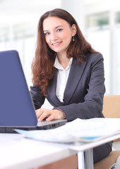Thoughtful business woman in an office smiling.