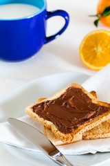 Breakfast with Chocolate Spread on Toast, Milk and Orange