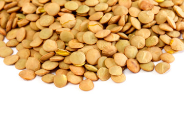 Brown lentils scattered on white background