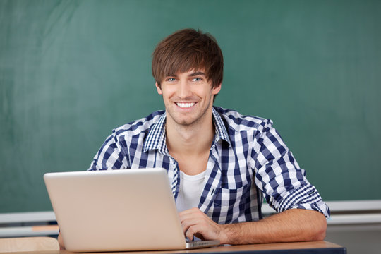 lächelnder student arbeitet am laptop