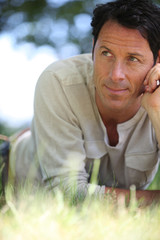 Man lying on the grass thinking.