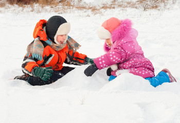Fototapeta na wymiar Boy and girl playing on the snow