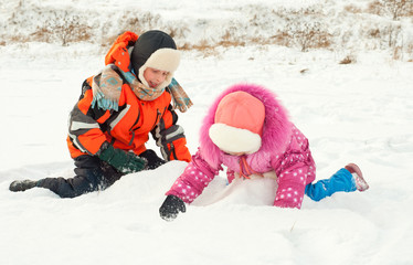 Fototapeta na wymiar Boy and girl playing on the snow