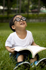 happy asian boy study on the green grass