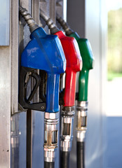 Three Colorful Pump Nozzles At The Gas Station