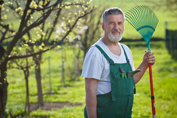 portrait of a senior man gardening in his garden