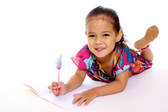 jolie petite fille apprend a écrire sur un cahier