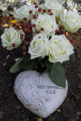 Rosenstrauss mit Herz auf einem Grab