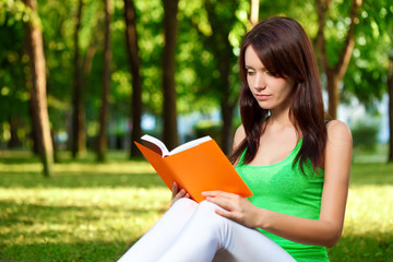 Obraz premium woman reading book at park