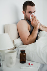 Portrait of an ill man blowing his nose