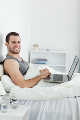 Portrait of a smiling man using a laptop