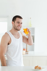 Fototapeta premium Portrait of a smiling man drinking orange juice