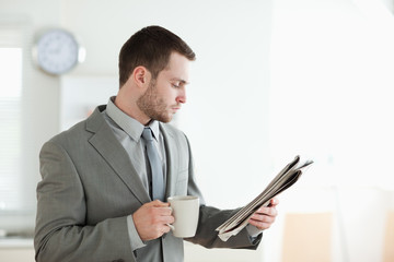 Businessman drinking tea while reading the news